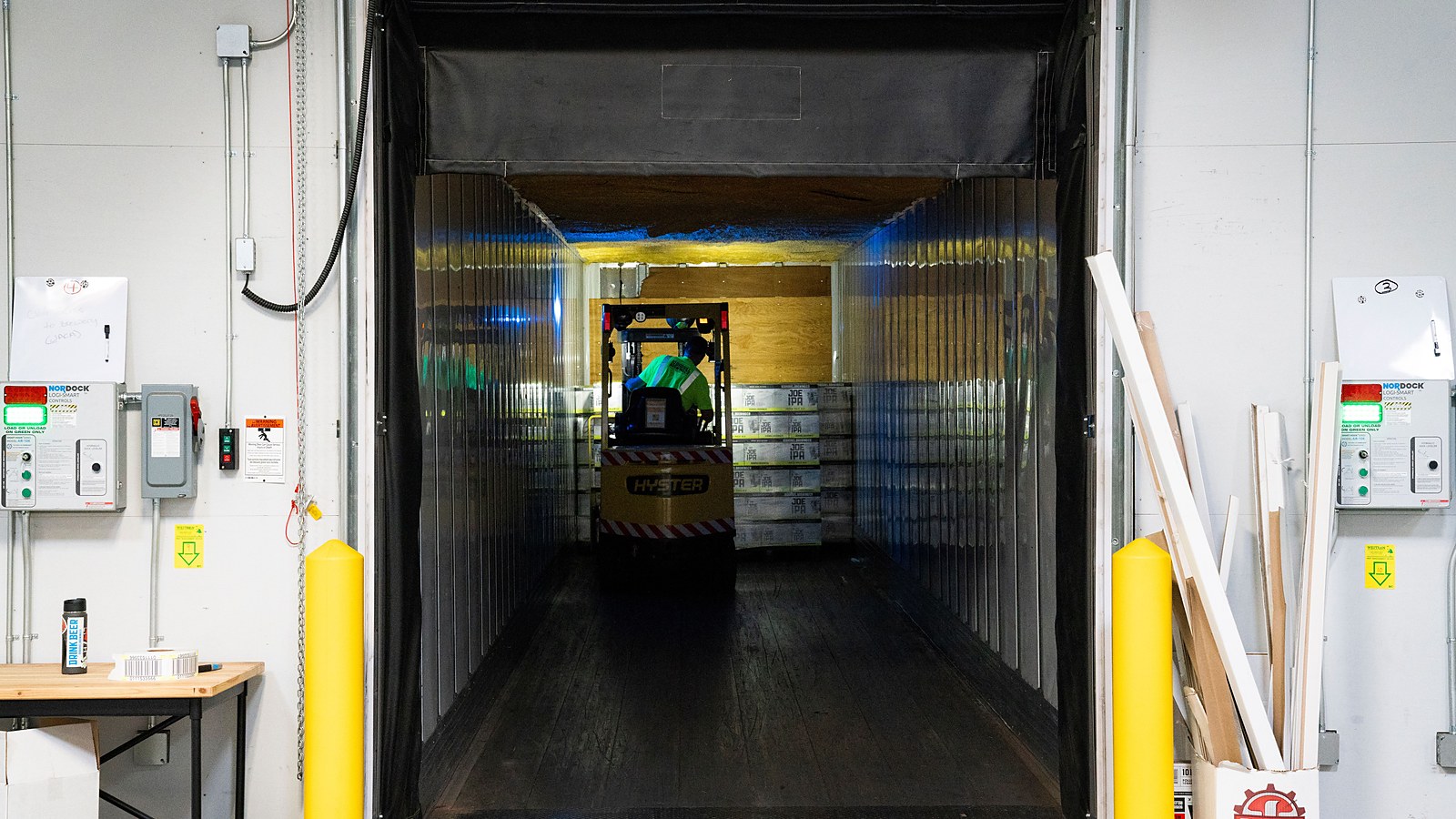 Porta de câmara fria industrial com cortina de tiras plásticas e empilhadeira ao fundo