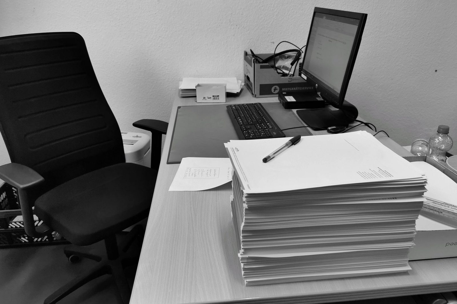 Pilha de documentos e processos sobre a mesa de trabalho