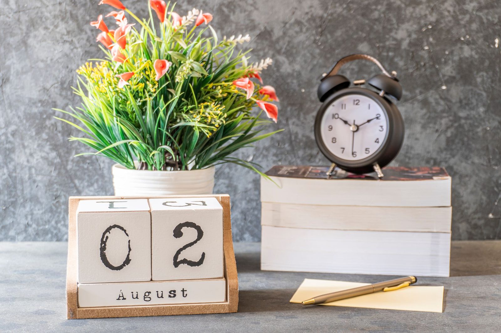 Calendario de blocos de madeira e despertador sobre a mesa