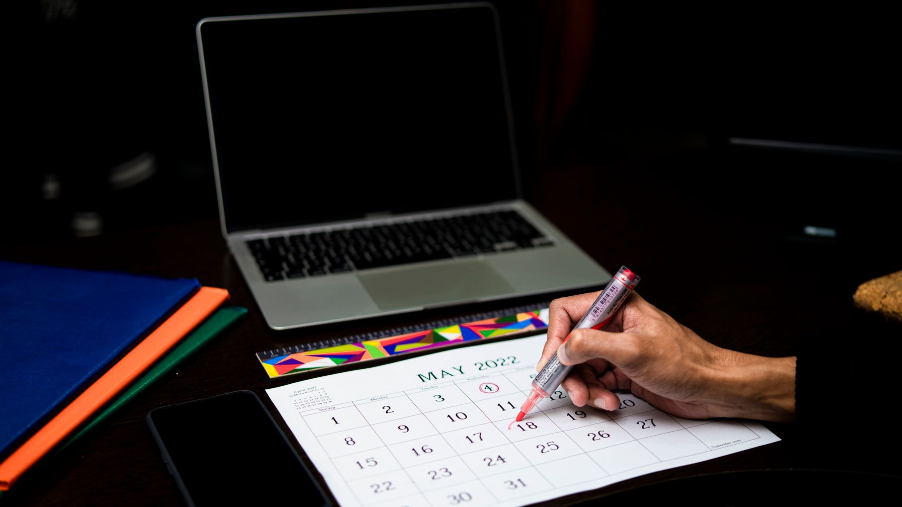 Calendário com caneta marcando uma data sobre a mesa, ilustrando os prazos e as providências de denúncia e de ação trabalhista descritos nesta seção.