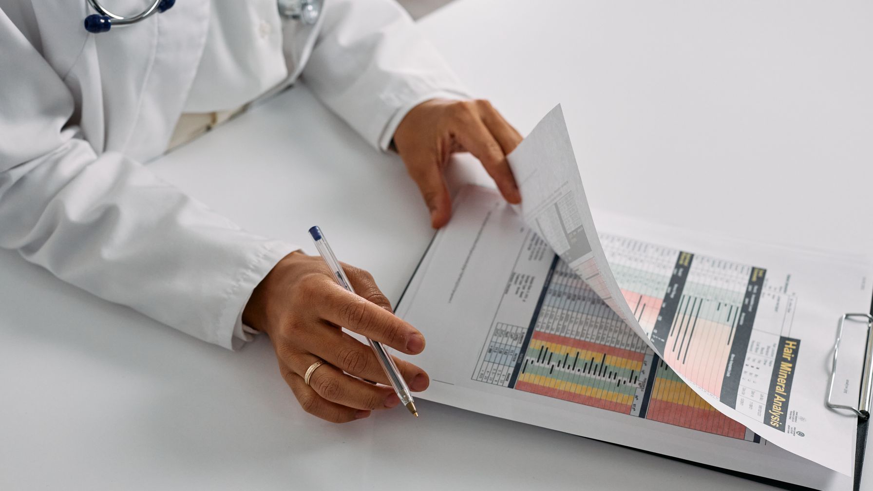 Estetoscópio apoiado sobre um laudo médico impresso, ilustrando o diagnóstico de doença ocupacional que chega depois da saída do frigorífico