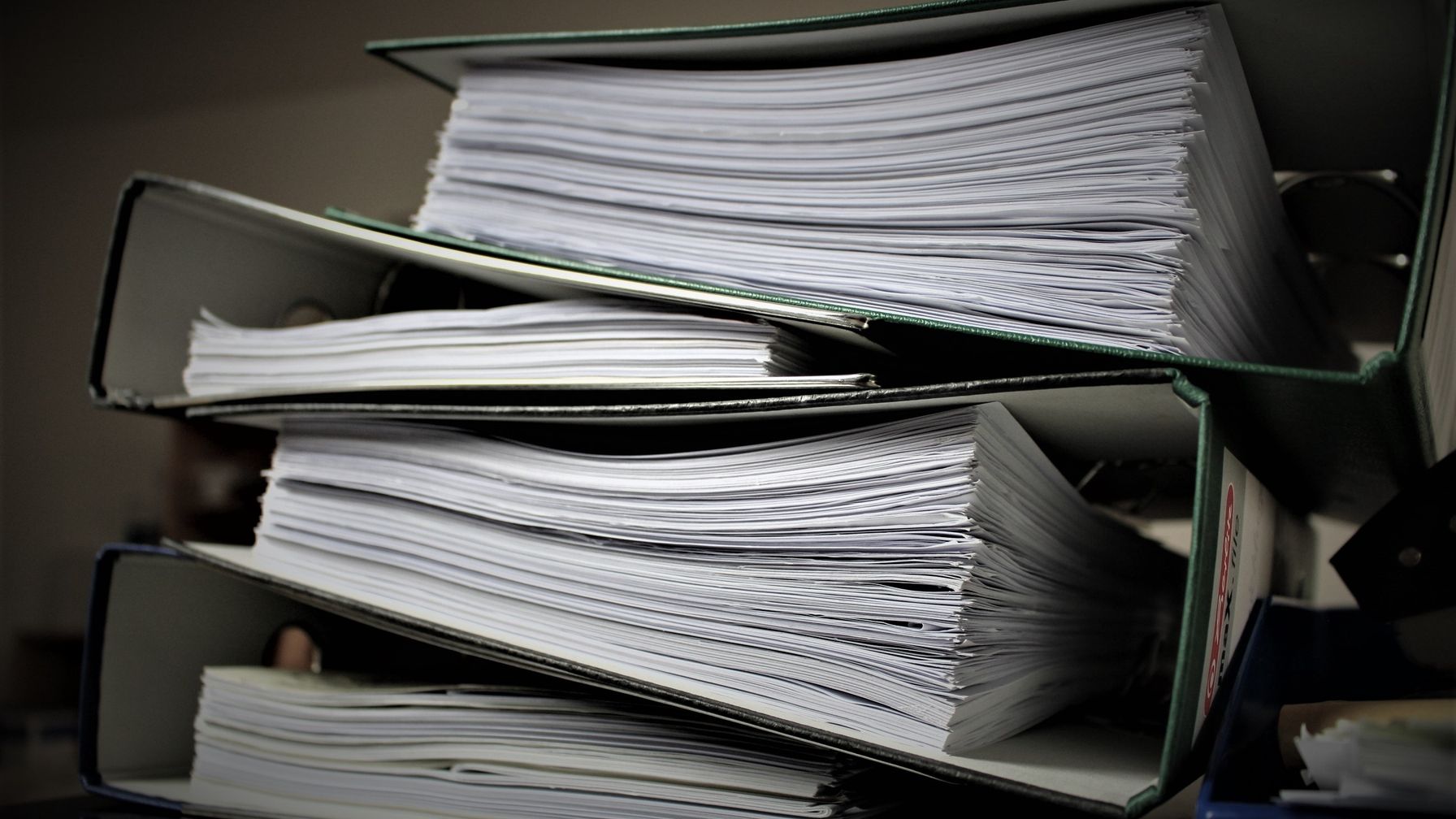 Pasta com documentos de papel e carteira de trabalho sobre mesa de escritório, ilustrando a reunião de CTPS física, contracheques e extrato do FGTS para o acerto do cadastro